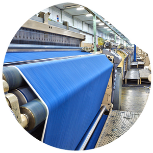 A large machine with several rollers in which a large blue fabric is inserted