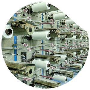 A machine with many spools in which large rolls of white yarn are clamped